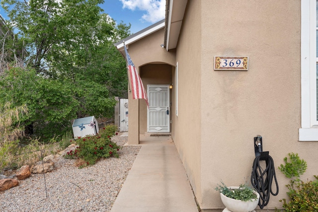doorway to property featuring stucco siding
