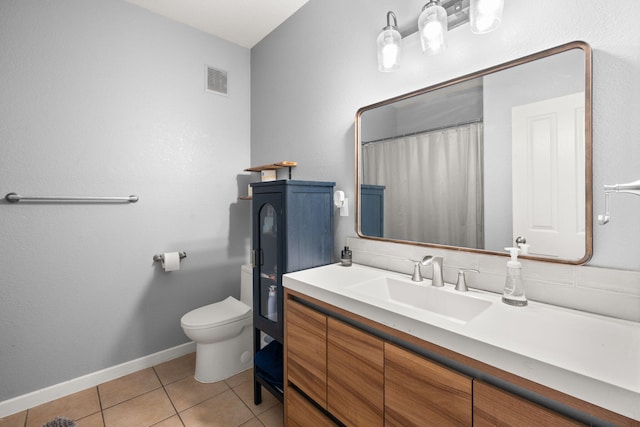 bathroom with toilet, visible vents, baseboards, tile patterned flooring, and vanity