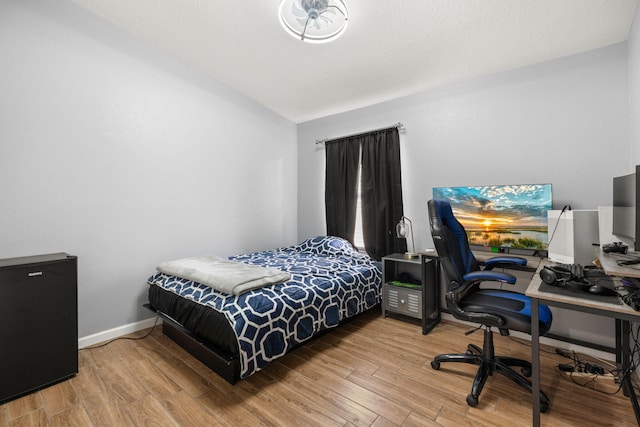 bedroom featuring vaulted ceiling, wood finished floors, and baseboards