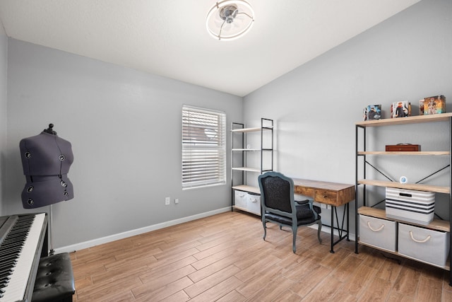 home office featuring vaulted ceiling, baseboards, and wood finished floors