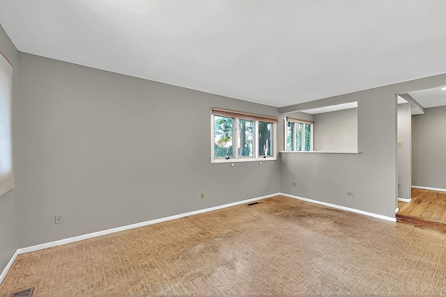 unfurnished room with baseboards and wood finished floors