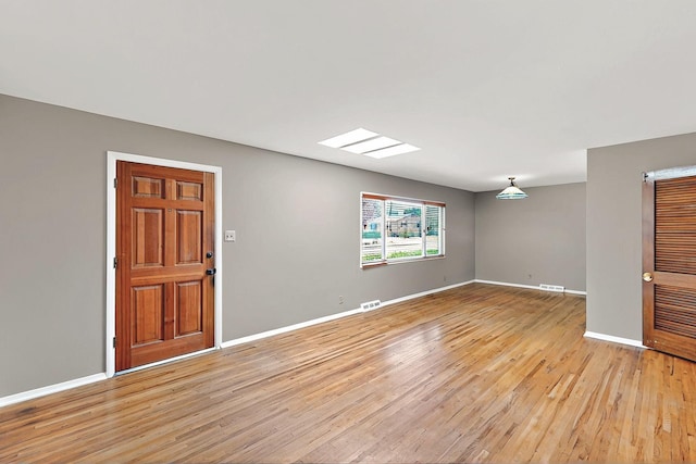 interior space featuring baseboards, light wood-style flooring, and visible vents