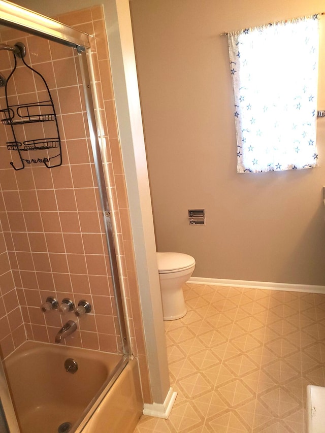 bathroom with baseboards, shower / bathtub combination, toilet, and tile patterned floors