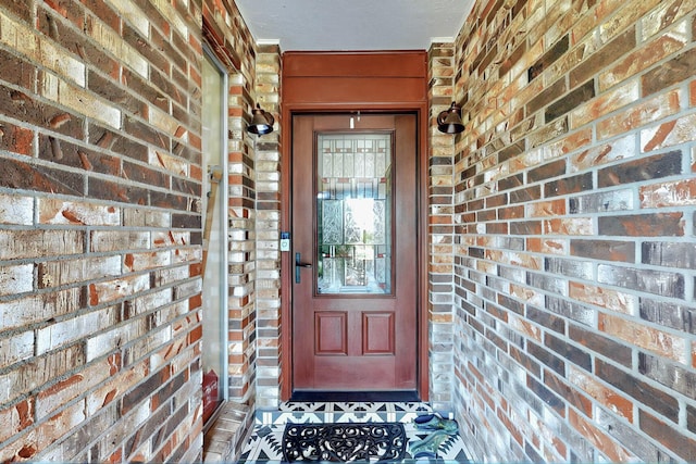 view of exterior entry featuring brick siding