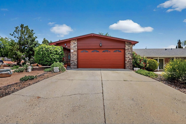 view of front facade with brick siding, a garage, and concrete driveway