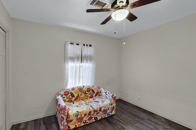 sitting room with baseboards, ceiling fan, visible vents, and wood finished floors