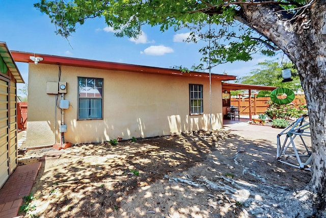 view of home's exterior with fence, a patio, and stucco siding