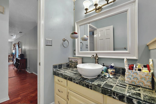 bathroom featuring vanity, baseboards, and wood finished floors