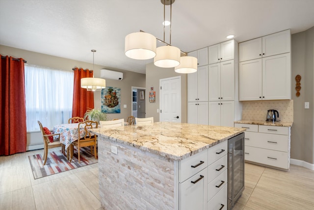 kitchen with beverage cooler, a wall unit AC, baseboard heating, and white cabinetry