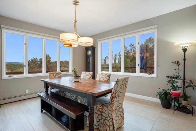 dining area with plenty of natural light, a baseboard radiator, and baseboards