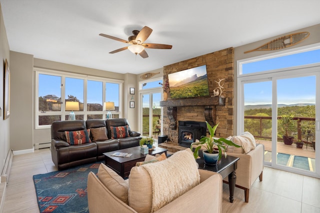 living room featuring baseboards, ceiling fan, baseboard heating, and a wealth of natural light