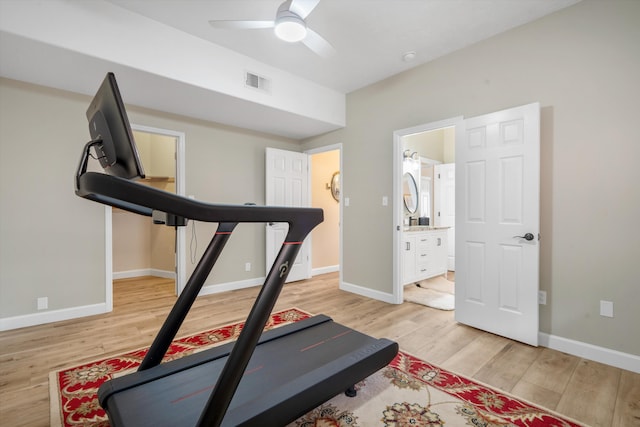 workout room with baseboards, ceiling fan, visible vents, and light wood-style flooring