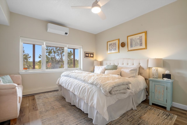 bedroom with an AC wall unit, baseboards, wood finished floors, and a baseboard radiator