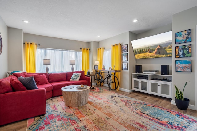 living area featuring baseboards, recessed lighting, and wood finished floors
