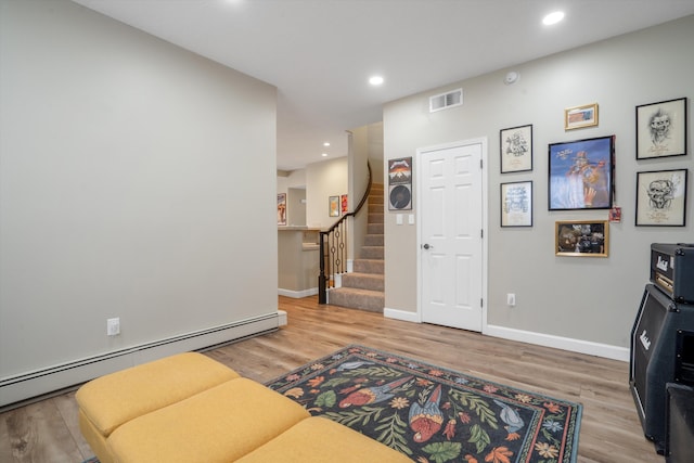 interior space with visible vents, stairs, wood finished floors, recessed lighting, and a baseboard heating unit
