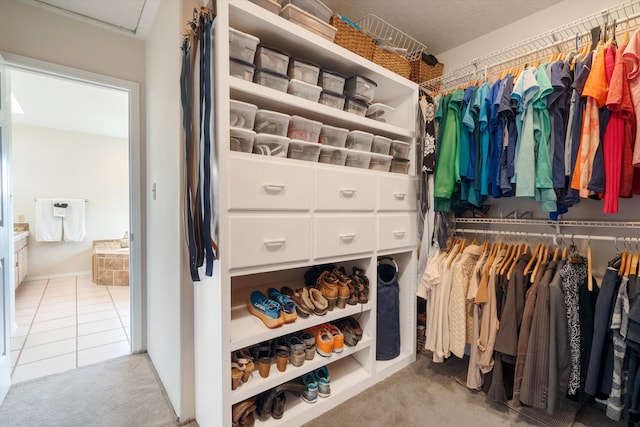 spacious closet featuring tile patterned floors and carpet