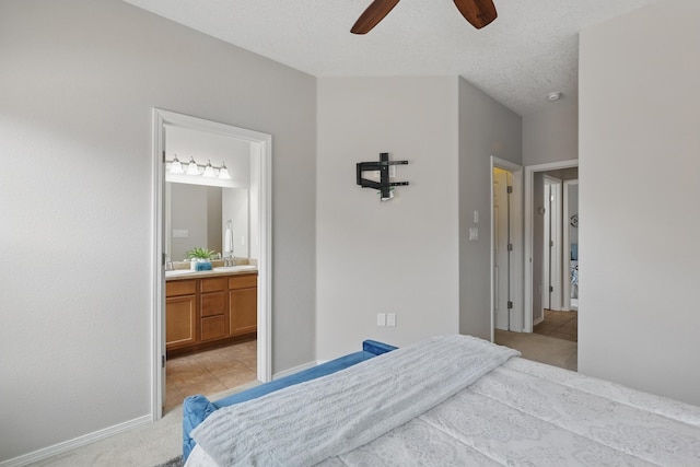 bedroom featuring light colored carpet, light tile patterned flooring, ensuite bath, and ceiling fan