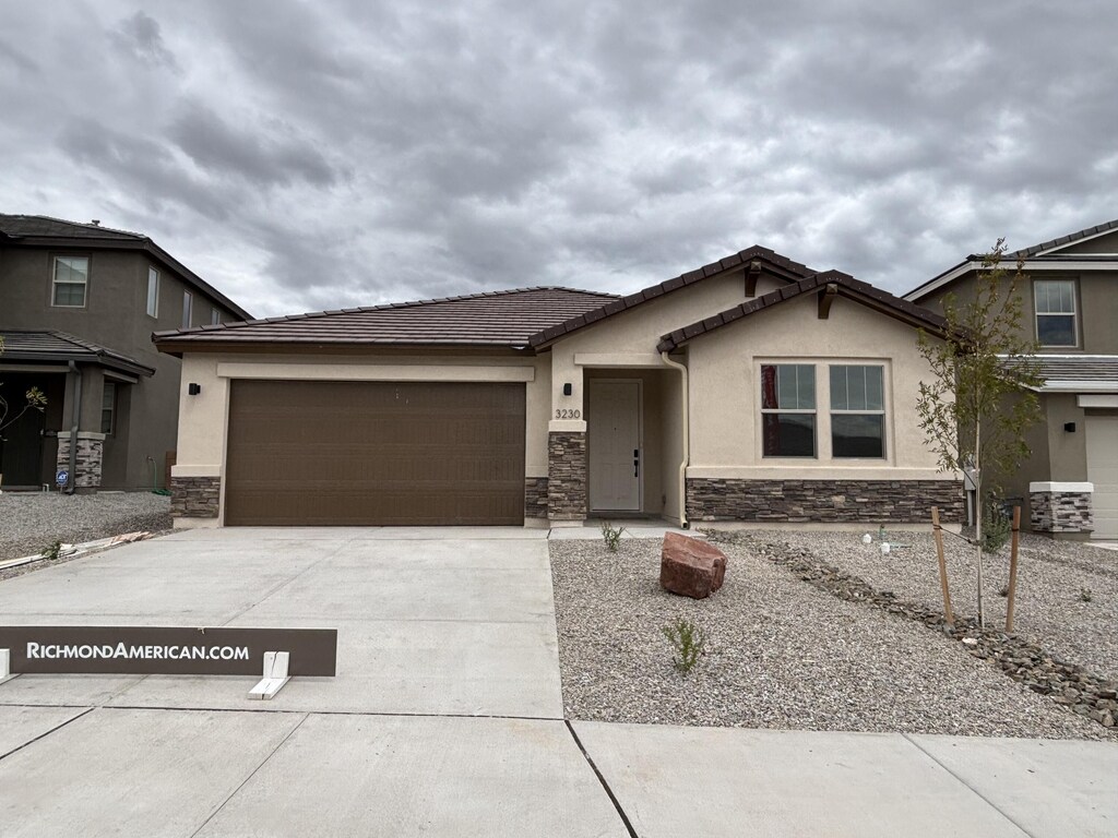 3230 Matador St SE, Rio Rancho, NM 87144 - ranch-style home featuring stucco siding, a garage, driveway, and stone siding