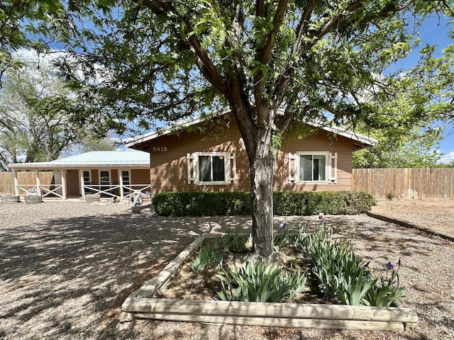 back of property featuring fence and metal roof