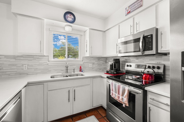 kitchen with stainless steel appliances, tasteful backsplash, light countertops, and white cabinets