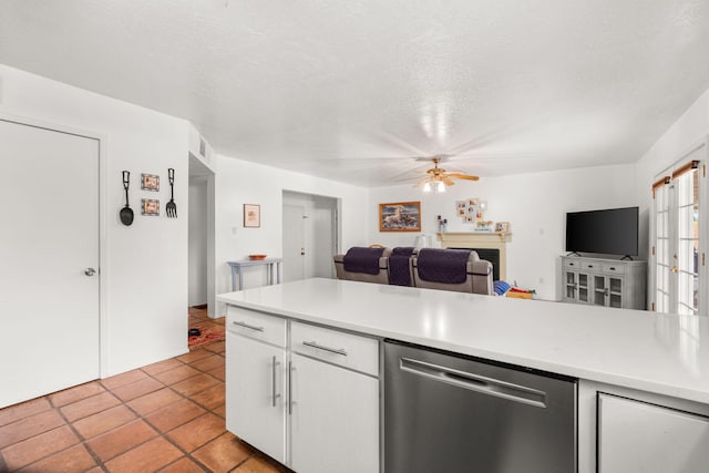 kitchen with stainless steel dishwasher, light countertops, white cabinetry, and open floor plan