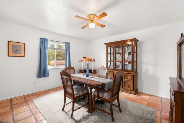 dining area featuring a ceiling fan, light tile patterned floors, and a textured ceiling