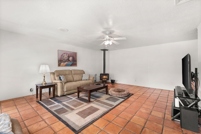 tiled living room featuring ceiling fan and a wood stove