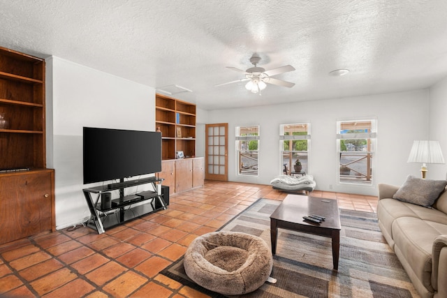 living room featuring a textured ceiling, built in features, a ceiling fan, and tile patterned flooring