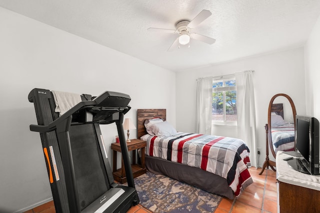 bedroom with a ceiling fan, a textured ceiling, and light tile patterned flooring
