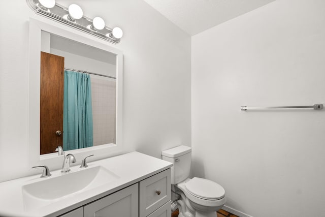 full bath with toilet, vanity, and curtained shower