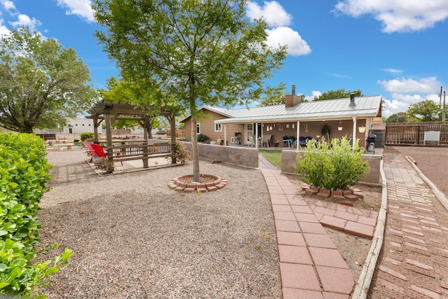 back of property featuring a pergola, a chimney, metal roof, a patio area, and fence