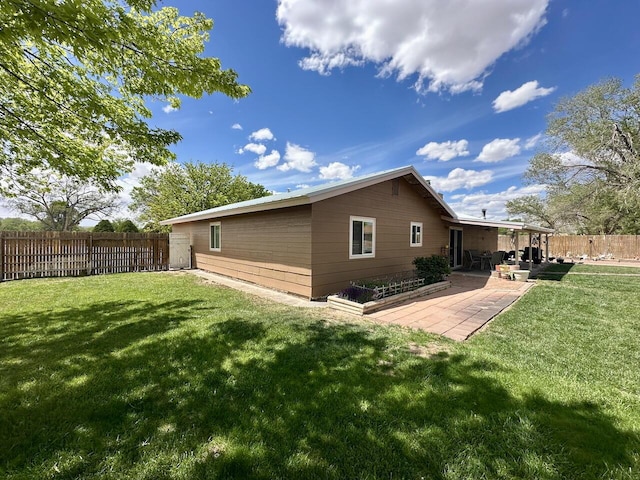 back of property with a lawn, a patio area, and a fenced backyard