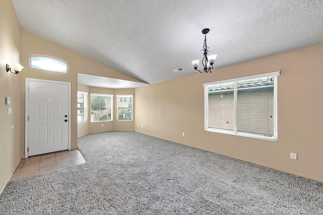 interior space with light colored carpet, a textured ceiling, visible vents, vaulted ceiling, and an inviting chandelier