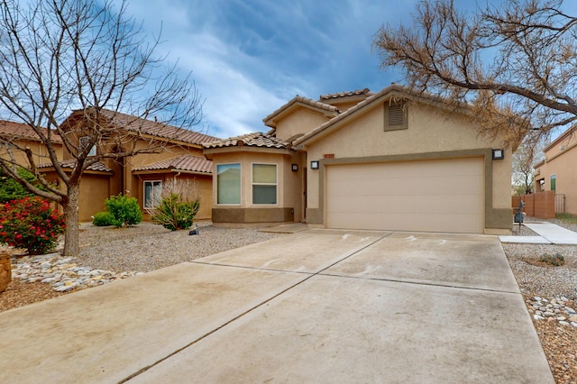 view of front facade featuring fence, driveway, a tile roof, a garage, and stucco siding