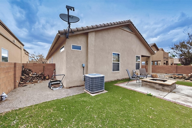 back of house with an outdoor fire pit, central air condition unit, stucco siding, and a patio