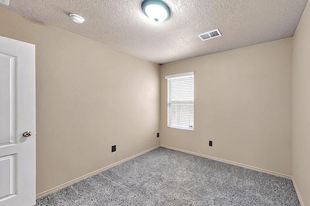 carpeted empty room with baseboards and a textured ceiling