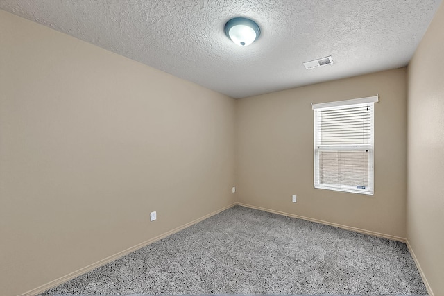 carpeted empty room with baseboards and a textured ceiling