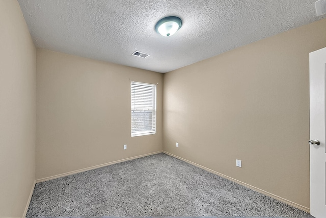 carpeted spare room featuring baseboards and a textured ceiling