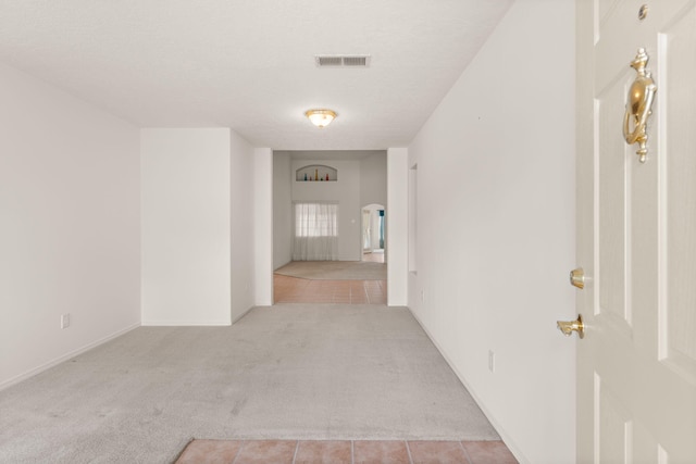 2105 Gila River Rd NE, Rio Rancho, NM 87144 - hallway with light carpet, light tile patterned flooring, and a textured ceiling