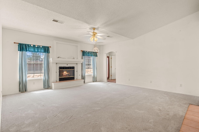 2105 Gila River Rd NE, Rio Rancho, NM 87144 - unfurnished living room featuring carpet flooring, a ceiling fan, healthy amount of natural light, arched walkways, and a textured ceiling