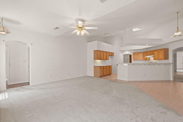 2105 Gila River Rd NE, Rio Rancho, NM 87144 - unfurnished living room with arched walkways, a ceiling fan, light carpet, light tile patterned floors, and lofted ceiling