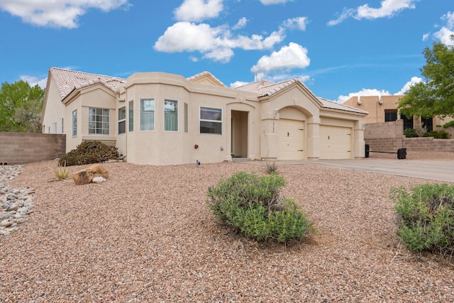 2105 Gila River Rd NE, Rio Rancho, NM 87144 - view of front facade with a garage, a tiled roof, driveway, and stucco siding
