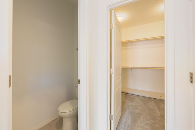 6791 Sydney Dr NE, Rio Rancho, NM 87144 - bathroom featuring toilet, baseboards, and a spacious closet