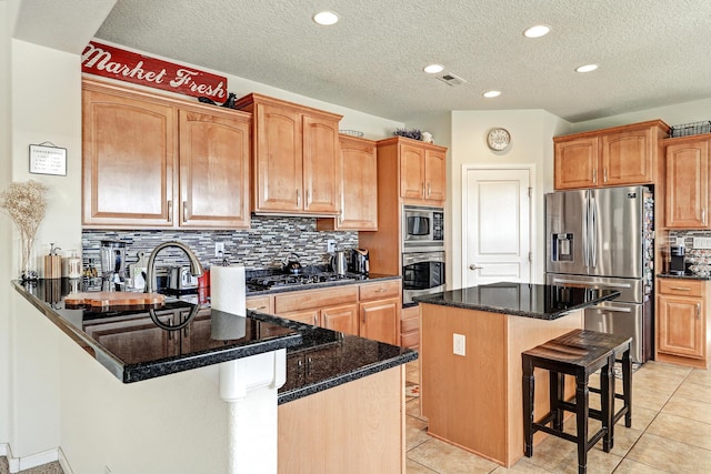 15 Los Miradores Dr NE, Rio Rancho, NM 87124 - kitchen with appliances with stainless steel finishes, a breakfast bar area, a peninsula, decorative backsplash, and a textured ceiling