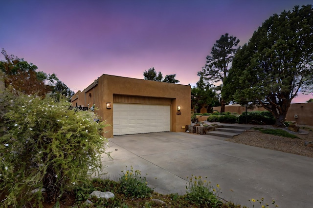 13108 Della Longa Ln NE, Albuquerque, NM 87111 - view of front of house with stucco siding, driveway, and a garage