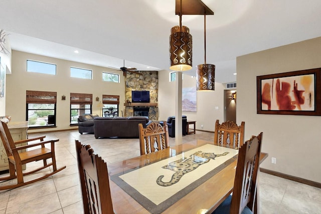 13108 Della Longa Ln NE, Albuquerque, NM 87111 - dining room featuring ceiling fan, light tile patterned flooring, a fireplace, baseboards, and recessed lighting