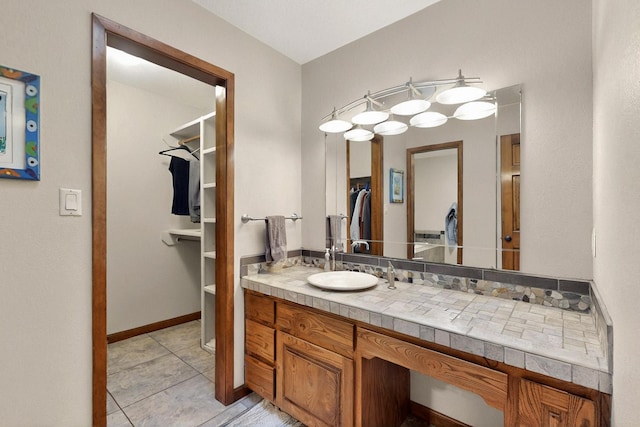 13108 Della Longa Ln NE, Albuquerque, NM 87111 - bathroom with vanity, a walk in closet, and tile patterned floors