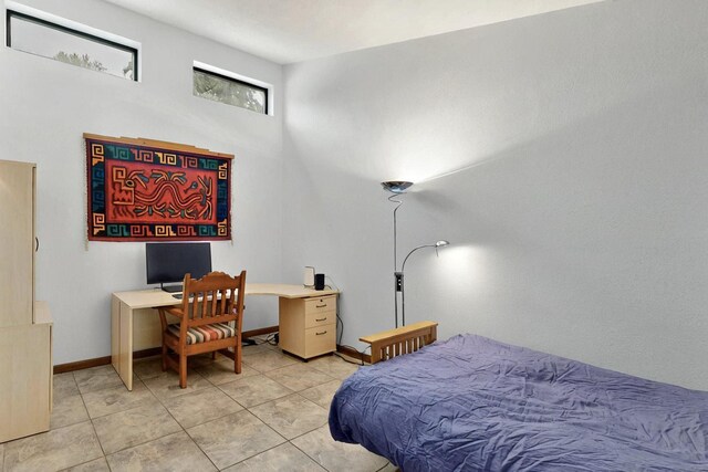 13108 Della Longa Ln NE, Albuquerque, NM 87111 - bedroom with light tile patterned flooring, a desk, and baseboards