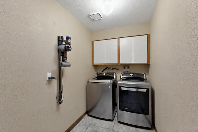 13108 Della Longa Ln NE, Albuquerque, NM 87111 - laundry room featuring cabinet space, washing machine and dryer, light tile patterned flooring, baseboards, and a textured ceiling