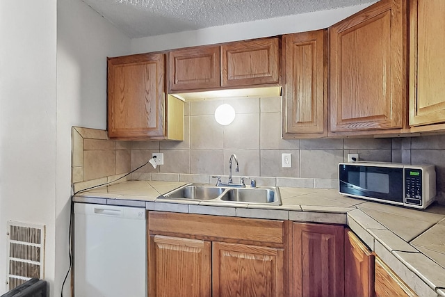 2800 Vail Ave SE Unit D113, Albuquerque, NM 87106 - kitchen with a sink, white dishwasher, tile counters, decorative backsplash, and heating unit